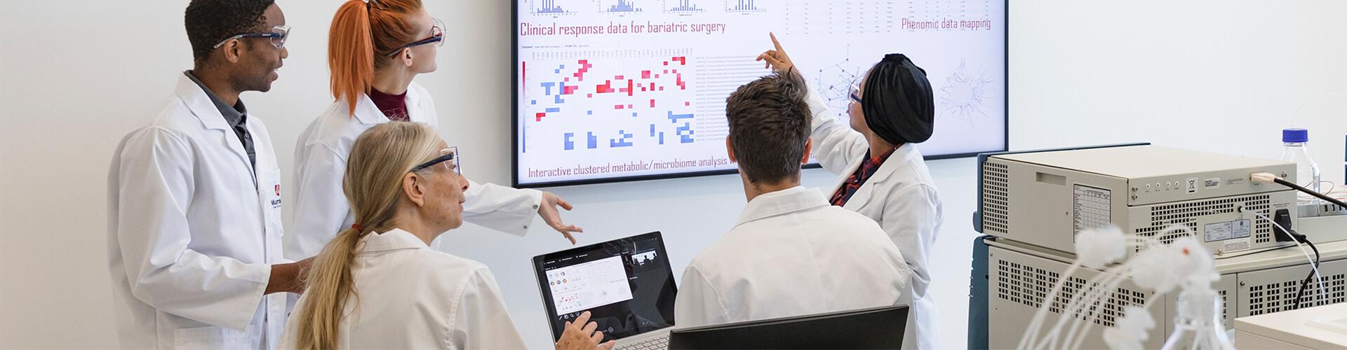 Group of researchers standing in front of whiteboard